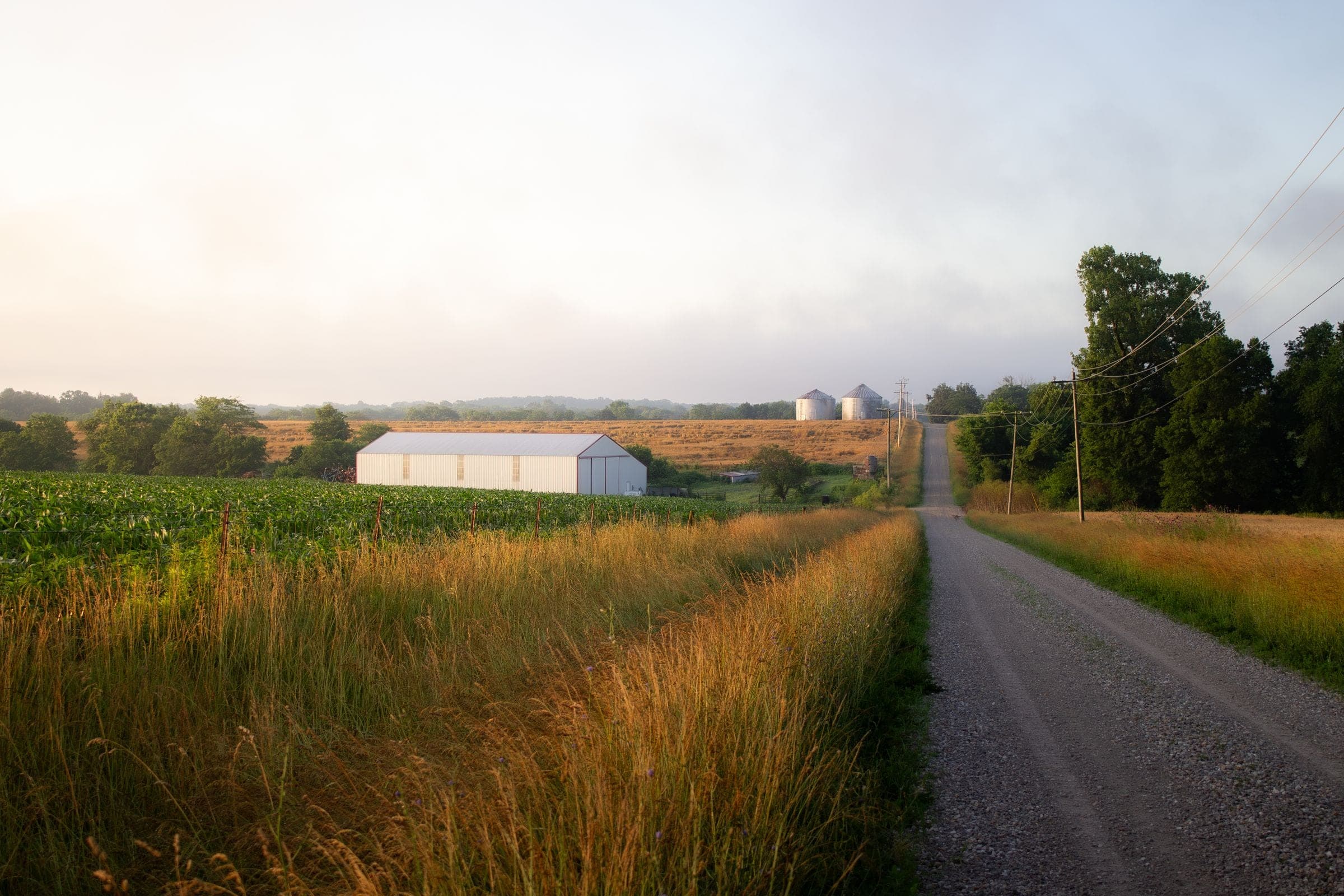 A gravel farm road past a machine shed and grain bins near Baltic, where we do mobile windshield replacement